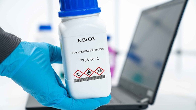 Person holding potassium bromate container