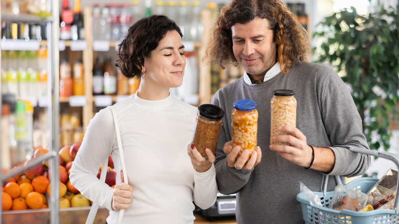 A couple choosing between several types of beans